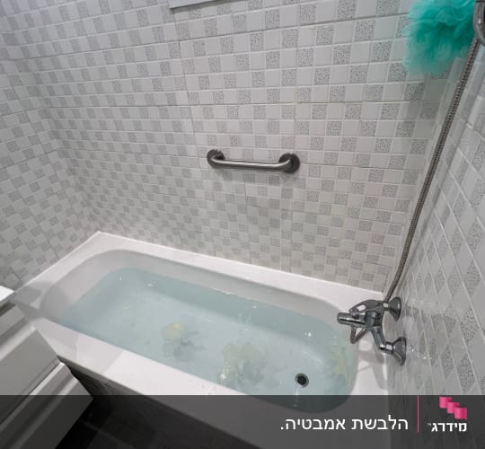 אמבטיה עם אריחים לבנים ומקלחת יד